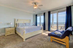 A bedroom with a bed, a nightstand, a chair, and a view of the ocean. - 🏖️Ocean Overlook-Beautiful 6BR Oceanfront Top 2 Floors of a Duplex🏖️ (Carolina Beach)