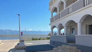 Un bâtiment moderne doté d’un balcon, d’un panneau de signalisation indiquant un arrêt obligatoire et offrant une vue dégagée sur les montagnes en arrière-plan.