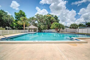 A rectangular pool with a 'NO DIVING' sign, surrounded by a fence, trees, and a gazebo. - Community Pool & Boat Ramp! Inverness Home (Inverness)