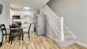 A modern kitchen with white cabinets, a stainless steel microwave, and a built-in oven.