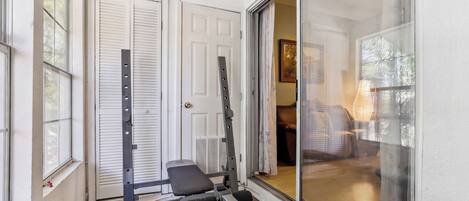 A home gym with a bench press, dumbbells, and a pull-up bar.
