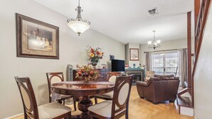 A dining area with a wooden table and chairs, a chandelier, and a flower vase. - Close to San Antonio Zoo & Airport: Cozy Townhome (San Antonio)