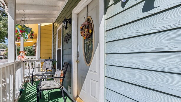 A porch with a welcome sign, outdoor furniture, and a decorative hanging. - Close to San Antonio Zoo & Airport: Cozy Townhome (San Antonio)