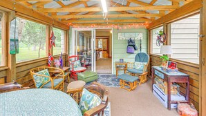 Een gezellig blokhutinterieur met houten balken, een eethoek en uitzicht op het omliggende landschap.