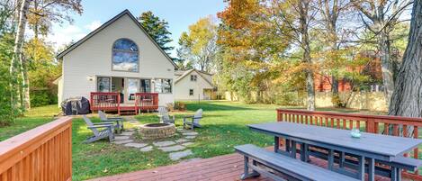 A house with a deck, a picnic table, and outdoor seating.