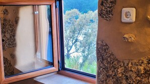 A room with a large window, a wooden frame, and a wall socket. - Encontro no Rio (Tábua)