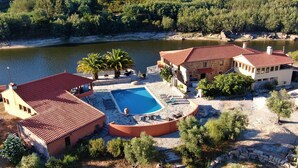 A villa with a swimming pool, stone buildings, and a forested hillside backdrop. - Encontro no Rio (Tábua)