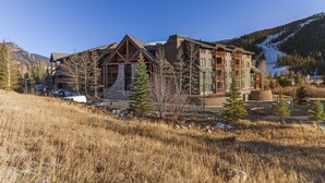 A lodge with a prominent wooden facade, multiple balconies, and a ski slope in the background. - Prime 3 Bedroom looking at Keystone Mtn House! (Keystone)