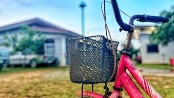 Una bicicleta roja con una canasta negra y manillar rojo.