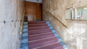 A staircase with marble walls and a wooden door at the top. - La Casa di Marygrace by Wonderful Italy (Turin)