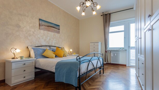 A bedroom with a bed, bedside tables, a nightstand, a window, and a radiator. - La Casa di Marygrace by Wonderful Italy (Turin)