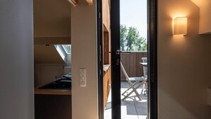 Een moderne keuken met dakraam, een eethoek met buitenzitplaatsen en een schuifpui die uitkomt op een terras.
