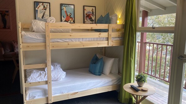 Dormitorio con literas, una mesita pequeña y una planta en maceta.