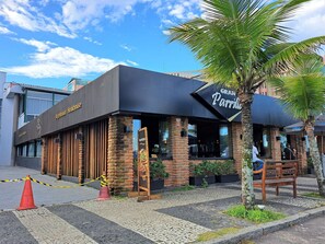 A restaurant named 'Gran Parrilla' with a brick facade, large windows, and outdoor seating.