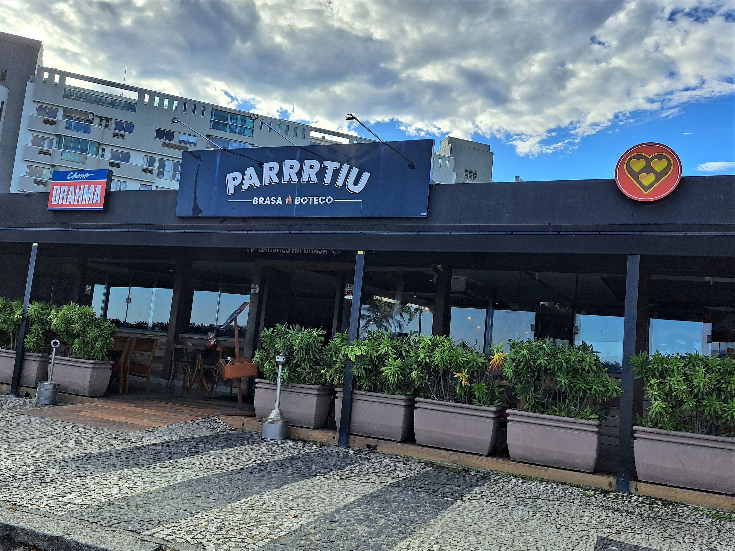 Ein Restaurant namens 'Parrrttiu' mit Außenbereich und Topfpflanzen.