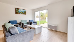 Ein modernes Wohnzimmer mit grauen Sofas, einem weißen Couchtisch und einem Bild an der Wand.