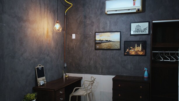 A room with a desk, chair, air conditioning unit, framed pictures, and a hanging light fixture. - paratemporada (Belém)