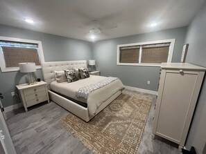A bedroom with a bed, nightstands, a lamp, a wardrobe, and a window with blinds. - Vanderbilt Beach North Naples, FL - 4 Bedroom, 3 Bath Home Steps From The Beach (Naples)