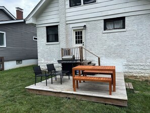 A backyard with a wooden deck, a grill, and outdoor seating. - Renovated Farmhouse + Fire Pit + Huge Yard + 4BR (Cincinnati)