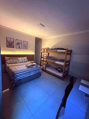 Un dormitorio con una cama, literas y un escritorio.