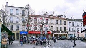 A street scene with buildings, a tram stop, and parked bicycles. - Studio Confortable Paris 13 (Paris)