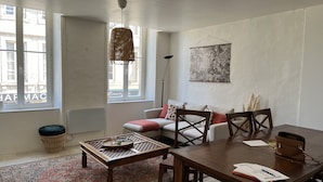 Una sala moderna con un sofá, una mesa de comedor y una lámpara colgante.