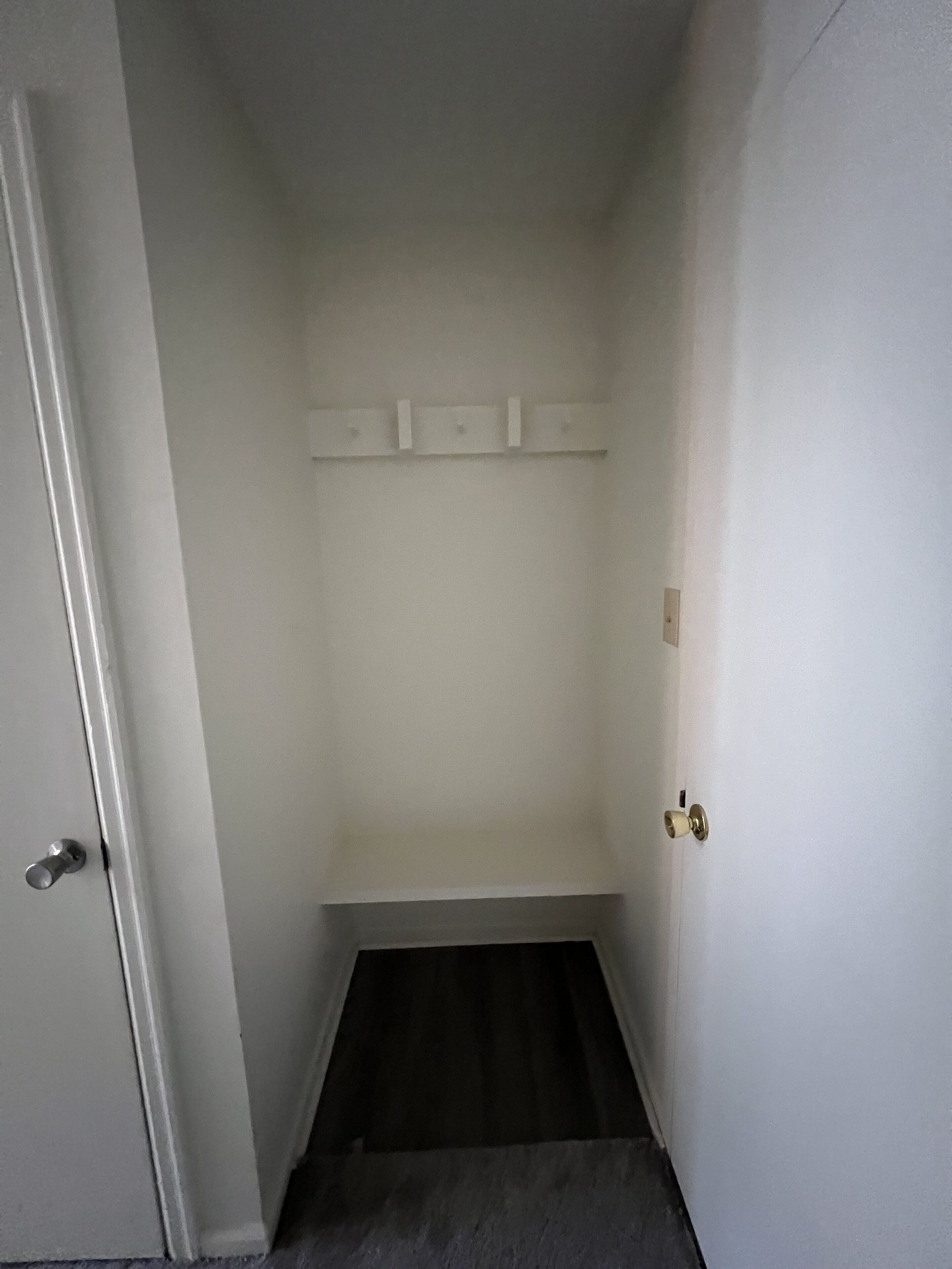 Un couloir étroit, avec une porte à gauche et une porte à droite.