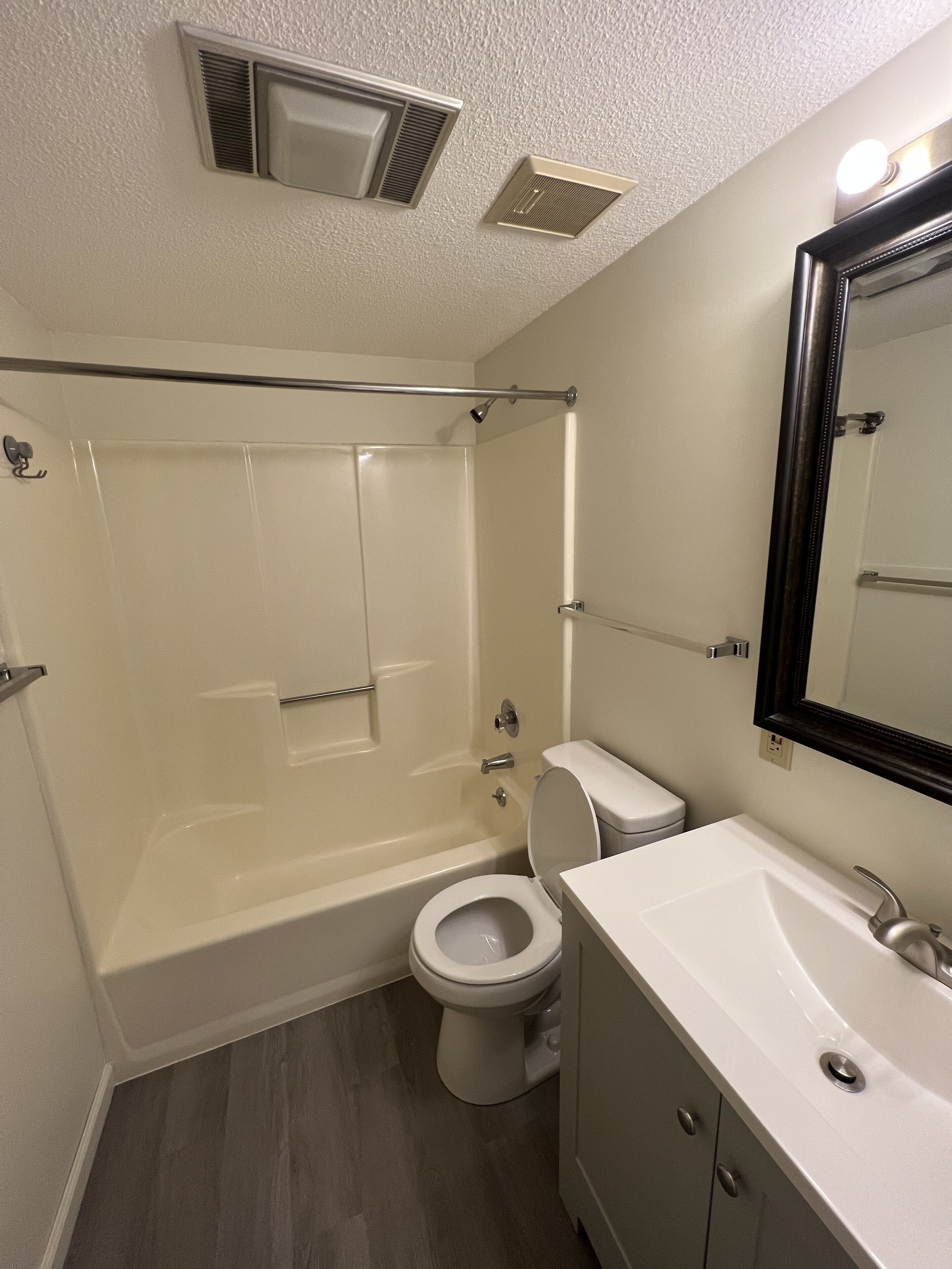 A bathroom with a bathtub, toilet, and sink.