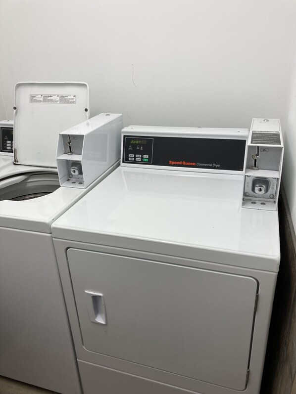 Una secadora comercial Speed Queen con panel de control, puerta y ranura para monedas de 25 centavos.