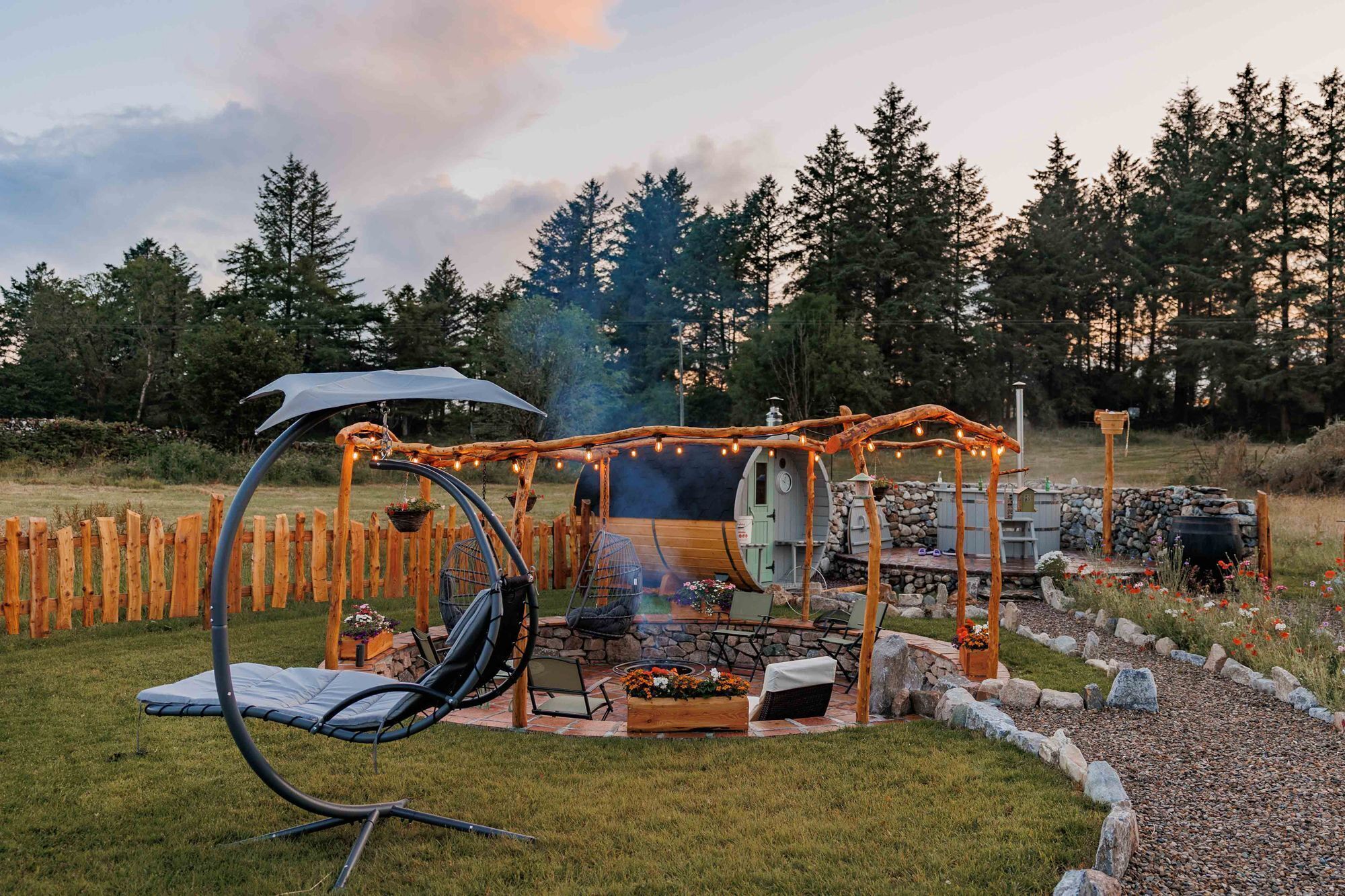 An outdoor patio with a grill, seating, and a swing chair.