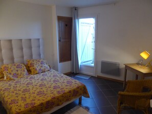 Cozy retreat with a plush bed, heart-shaped door decoration, and a comfortable wicker chair.