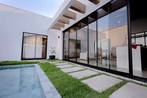 A modern house with a swimming pool, large glass windows, and a well-maintained lawn. - Alter Casa Cocar - Casa Completa em Alter do Chão Brasil (Alter do Chão)