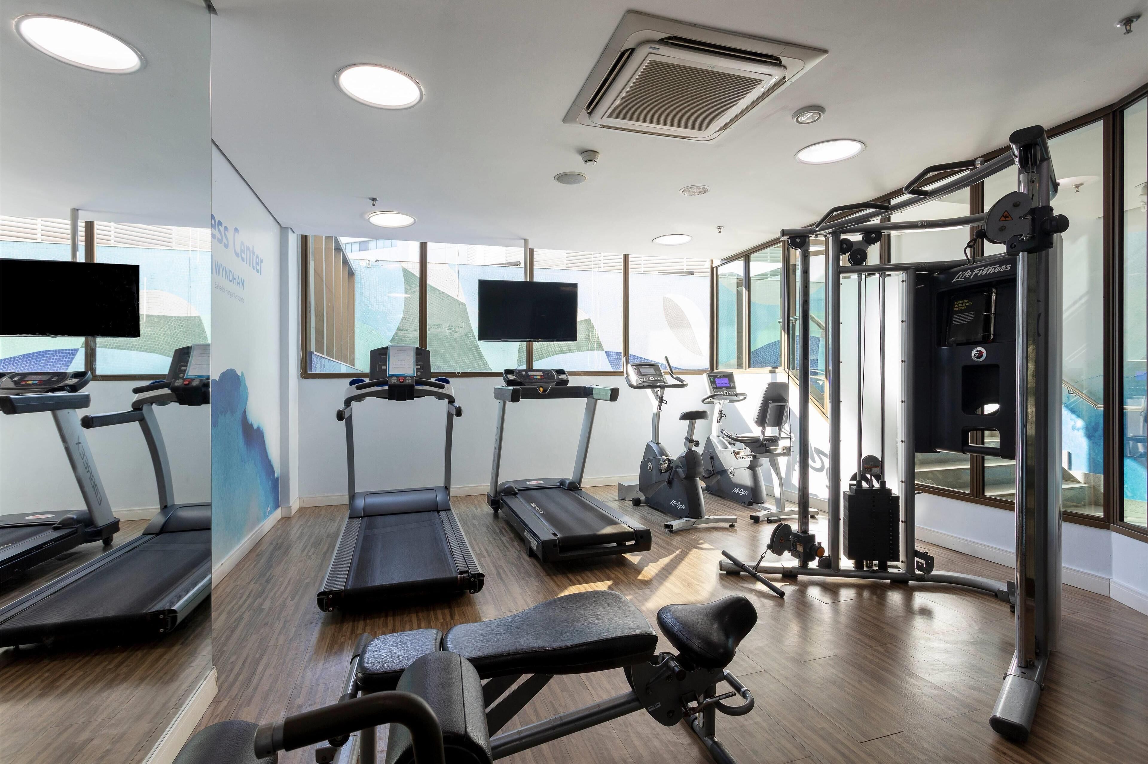 A gym with treadmills, stationary bikes, and a weight machine.