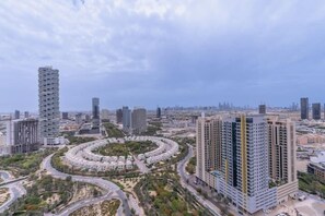 A modern urban landscape with high-rise buildings, a circular road layout, and a mix of residential and commercial structures. - Vogue JVC - Regina Tower (Dubai)