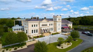 A large, historic building with a symmetrical facade, multiple chimneys, and a central entrance with steps. - Manor House Country Hotel (Enniskillen)
