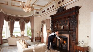 A grand room with a fireplace, a sofa, and a chandelier. - Manor House Country Hotel (Enniskillen)