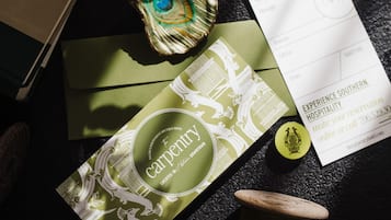 A table with a gift voucher, a card, a spool of thread, and a decorative item.