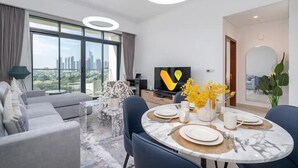Uma sala de estar moderna com área de jantar, janelas amplas e vista para a cidade.
