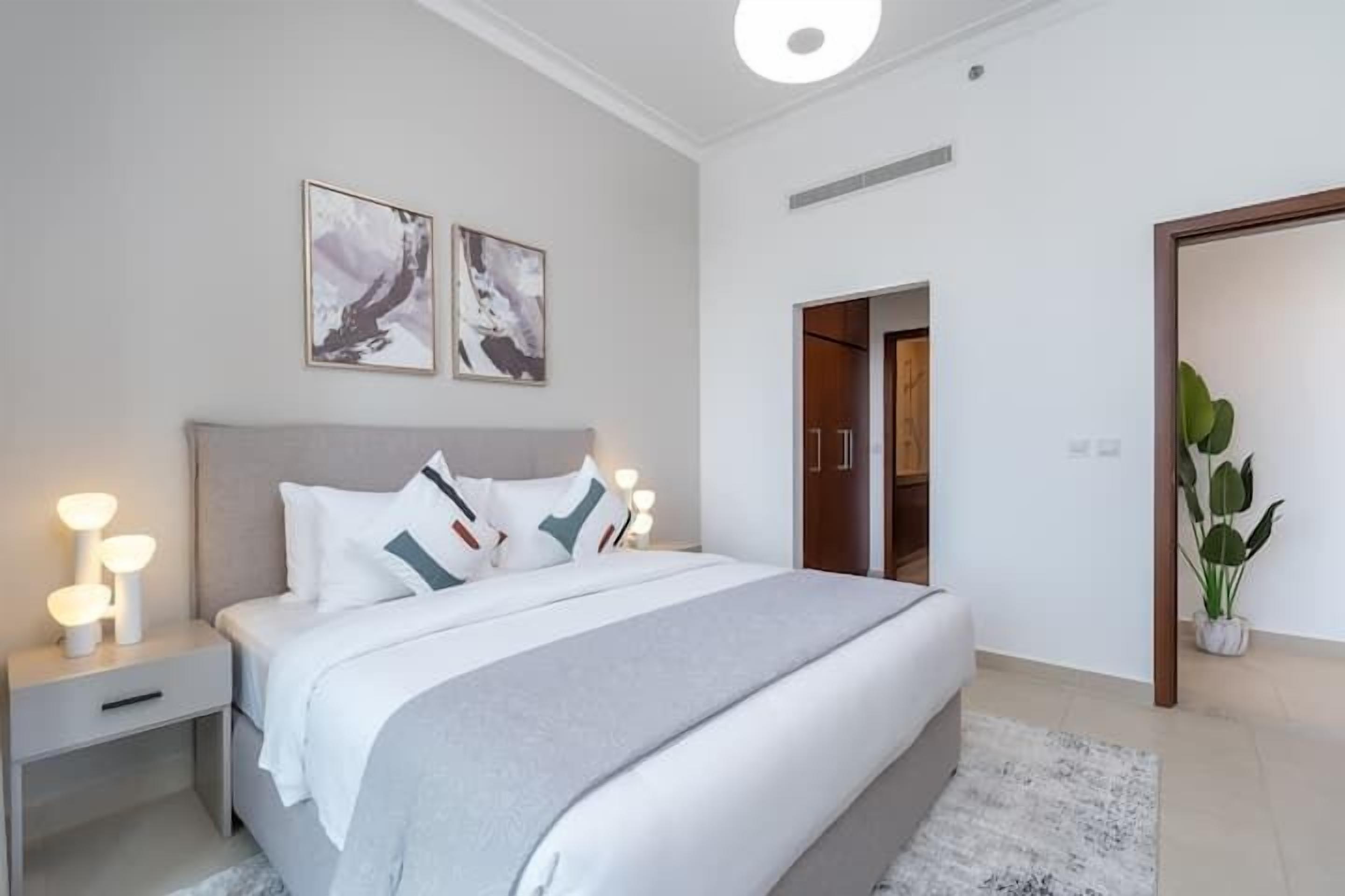 Un dormitorio moderno con cama, mesitas de noche y decoración en la pared.