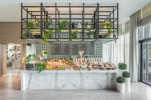 A marble counter with plants, a menu board, and a modern interior design.