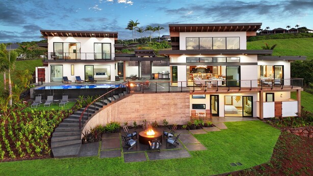 Uma casa moderna de dois andares com piscina, área de estar externa e lareira.
