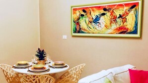 Un comedor con una mesa redonda, sillas y un cuadro en la pared.