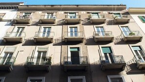 Un edificio de varios pisos con balcones, ventanas y cielo despejado.
