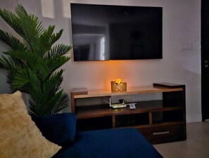 Relax in this stylish living room with a flat-screen TV, entertainment unit, and plush sofa.