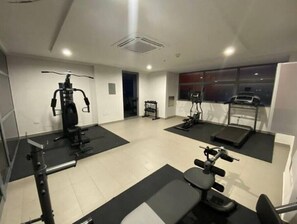 Work out in style with a variety of exercise equipment, including a stationary bike, treadmill, and bench press.