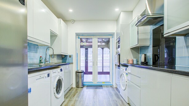 Una cucina moderna con elettrodomestici integrati, un'ampia finestra e vista all'esterno.