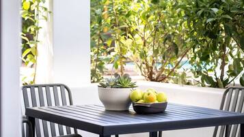 A table with a potted plant and a bowl of apples.