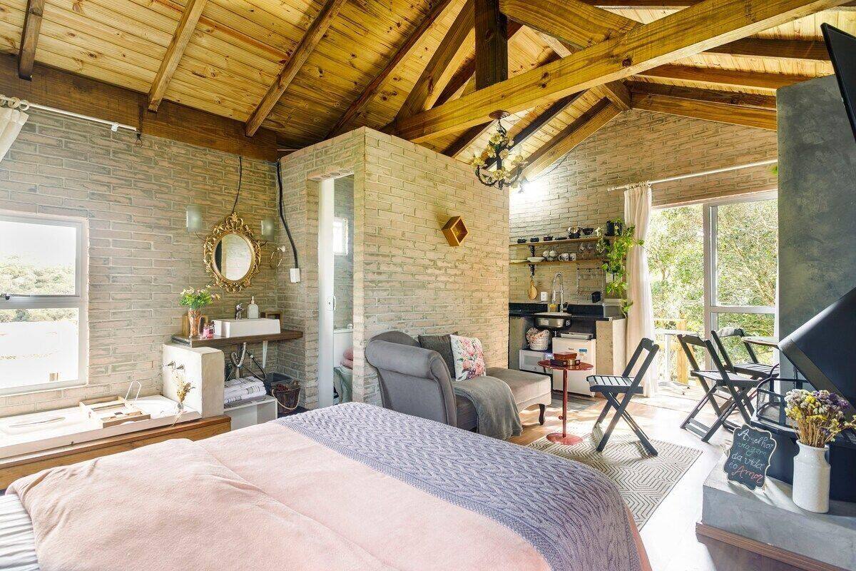 A cozy bedroom with a large bed, a desk, a chair, and a window.