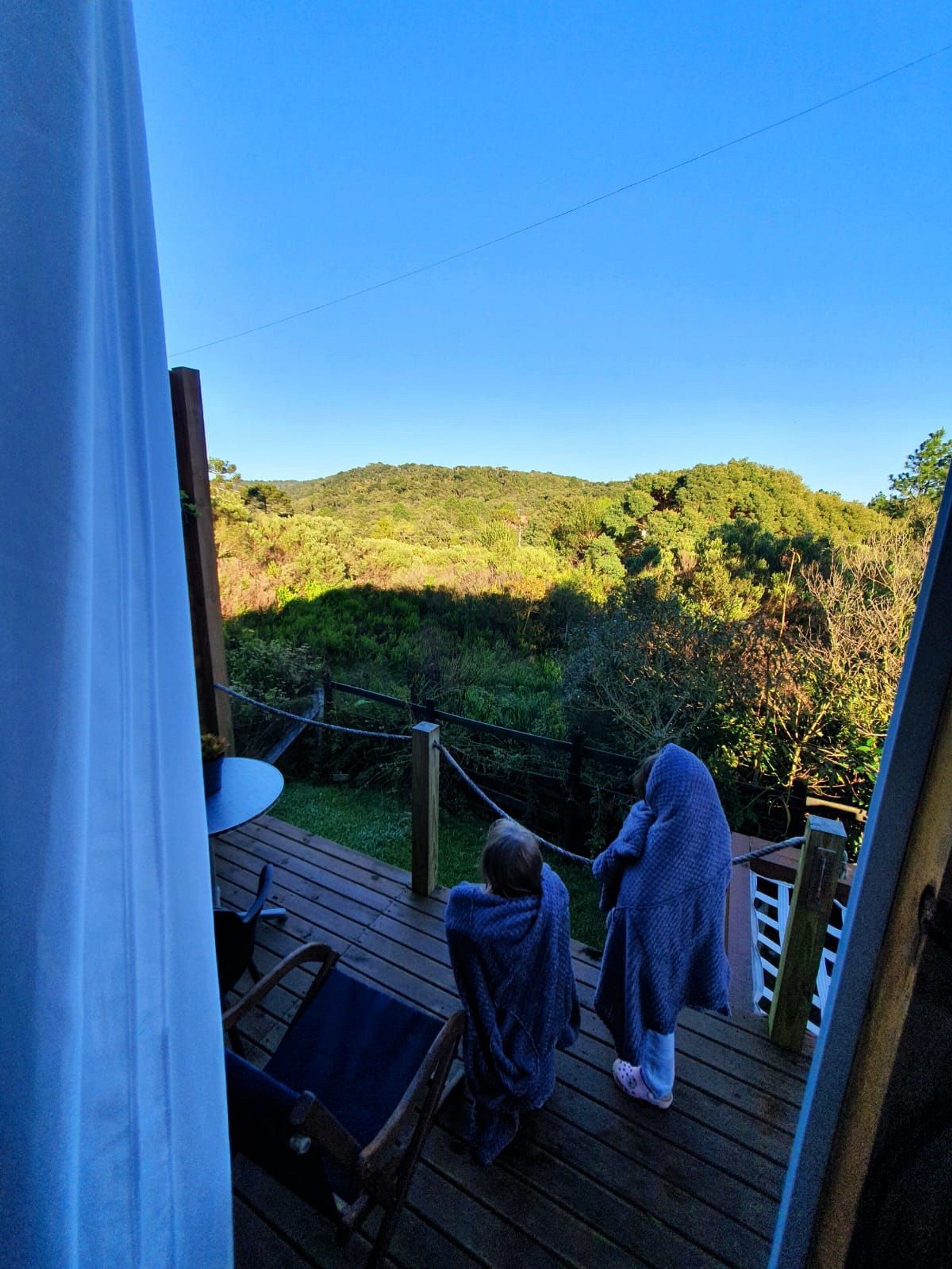 Un terrazza in legno con vista su un pendio verde.