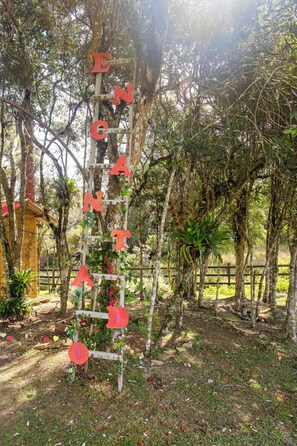 Una escalera de madera con letras que deletrean “ENCHANTED” en un entorno de jardín.